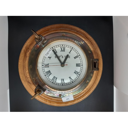 371 - A vintage style brass cased ships wall clock on oak circular back - back measuring approx. 31cm in d... 