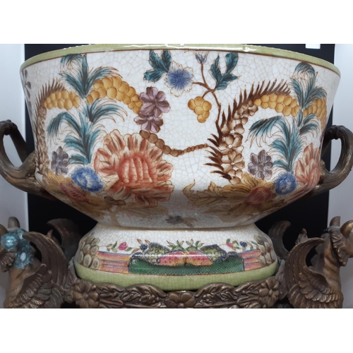 381 - An antique style hand painted porcelain and cast metal twin handled centrepiece supported on a pair ... 