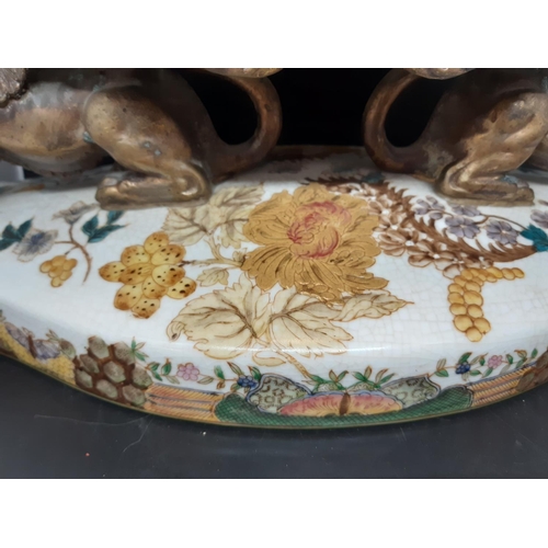 381 - An antique style hand painted porcelain and cast metal twin handled centrepiece supported on a pair ... 