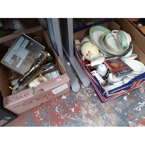 409 - Seven boxes containing mixed items to include a West German pottery handled vase, books, brass effec... 