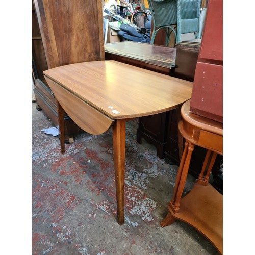 580 - A mid 20th century teak effect drop leaf dining table