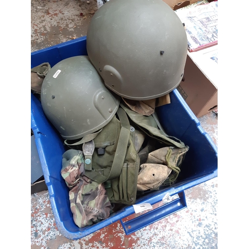 448 - A box containing a collection of modern military uniform to include two helmets, jackets, holders et... 