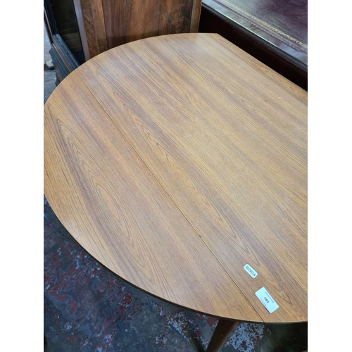 580 - A mid 20th century teak effect drop leaf dining table