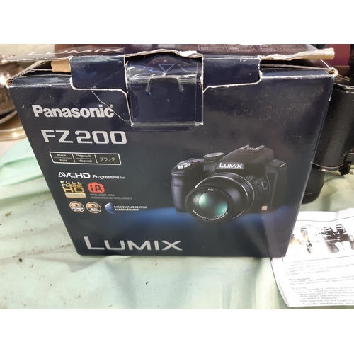 388E - Four items to include a pair of Ajax 7x50mm field binoculars, a boxed Panasonic lumix DMC-FZ200 digi... 