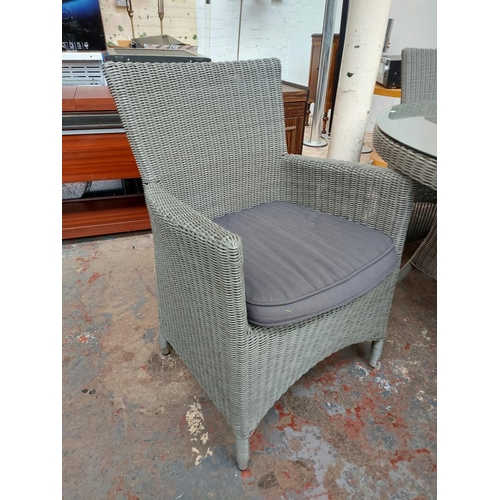 721 - A five piece grey plastic rattan effect patio set comprising circular glass top table and four match... 