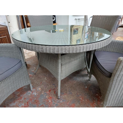 721 - A five piece grey plastic rattan effect patio set comprising circular glass top table and four match... 