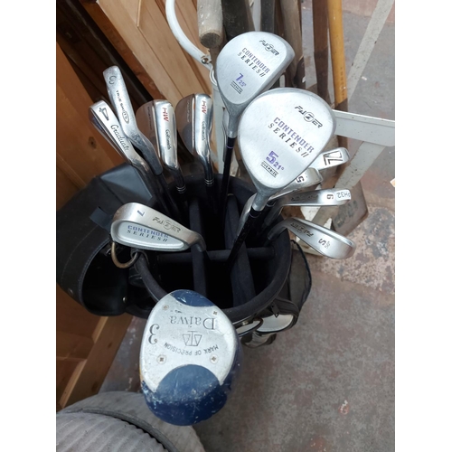 762 - A black and white Spalding golf bag containing Fazer, Daiwa and Graduate golf clubs