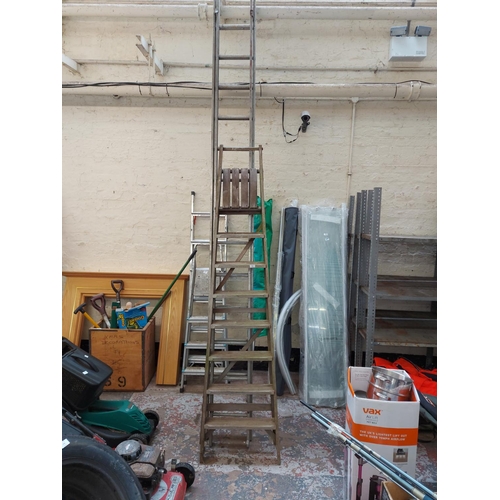 822 - Two items to include a set of wooden eight tread step ladders and an aluminum double extendable twen... 