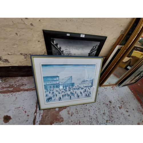 430 - Two framed prints to include L.S. Lowry 'Going to the match 1953' and a church scene