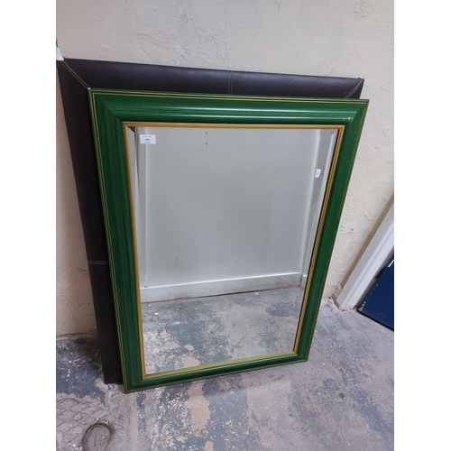 435 - Two mirrors to include a green painted framed bevelled edge mirror and a brown leather framed mirror