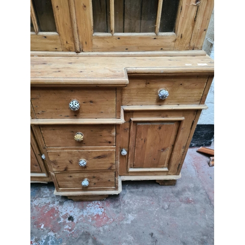 456 - A Victorian pine farmhouse dresser with two upper glazed doors, three internal shelves, four central... 