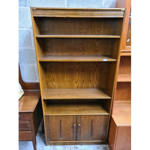 462 - An oak freestanding open bookcase with two lower cupboard doors and three sheves