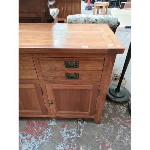 469 - A modern oak sideboard with three drawers and three lower cupboard doors - measuring approx. 160cm x... 