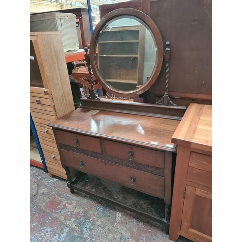 470 - An early 20th century oak dressing table on barley twist supports with upper bevel edged circular mi... 