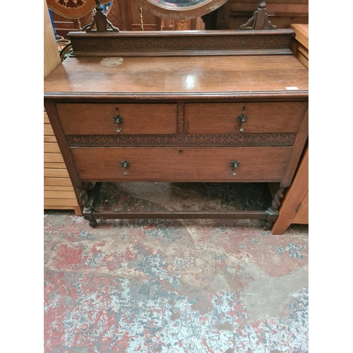 470 - An early 20th century oak dressing table on barley twist supports with upper bevel edged circular mi... 