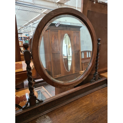 470 - An early 20th century oak dressing table on barley twist supports with upper bevel edged circular mi... 