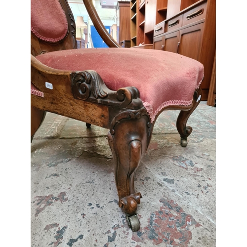 479 - A Victorian mahogany ladies parlour chair on scrolled supports and castors with pink upholstery