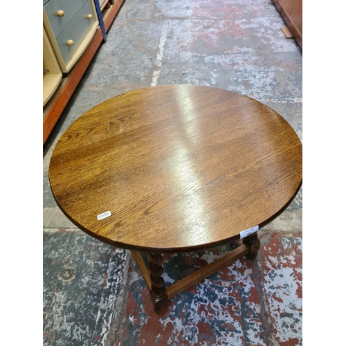 489 - Two items to include an oak circular side table on barley twist supports and a vintage walnut sewing... 