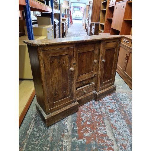 498 - A Victorian pine sideboard with two outer cupboard doors, one central door and two lower drawers