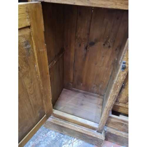 498 - A Victorian pine sideboard with two outer cupboard doors, one central door and two lower drawers