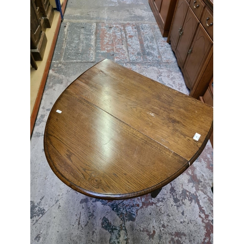 502 - An oak drop leaf gate legged oval occasional table