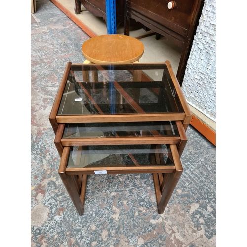 516 - A teak nest of three tables with smoked glass inserts and a modern bentwood stool