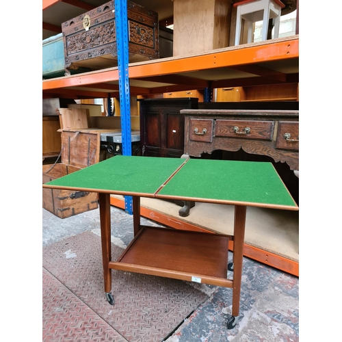 521 - A mid 20th century Eastcraft of Scotland teak two tier fold out games trolley with green baize top