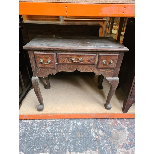 534 - An Edwardian oak writing table on cabriole supports with three drawers - measuring approx. 77cm high... 