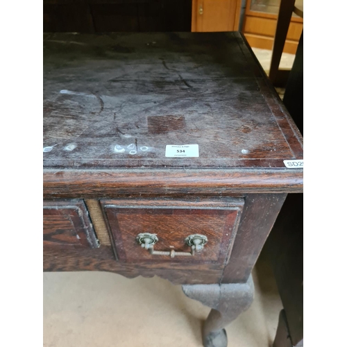 534 - An Edwardian oak writing table on cabriole supports with three drawers - measuring approx. 77cm high... 