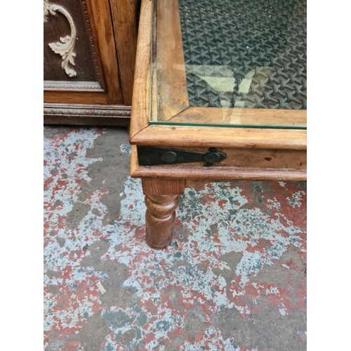 542 - An Indian sheesham wood square coffee table with glass top and wrought iron insert