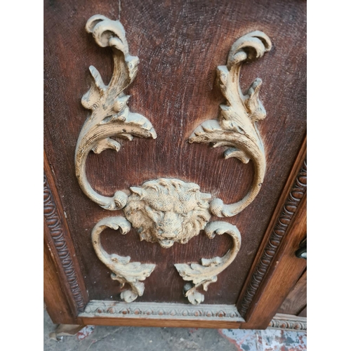 543 - An early 20th century heavily carved oak mirror backed sideboard with rectangular bevel edged mirror... 