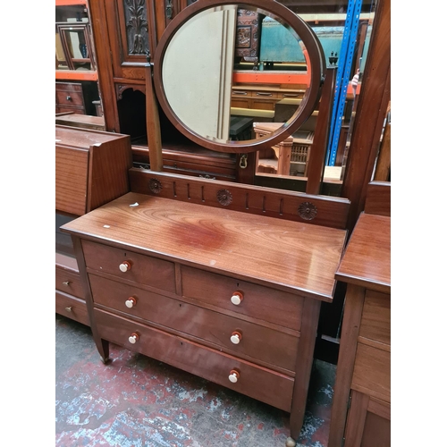 552 - An Edwardian mahogany three piece bedroom suite comprising single door wardrobe with oval bevel edge... 