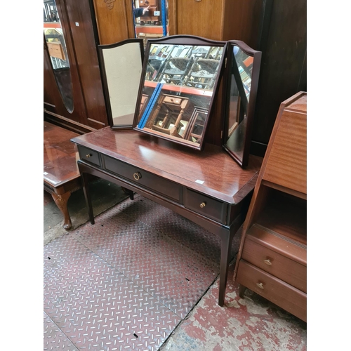 554 - A Stag minstrel mahogany dressing table with three drawers and upper three section mirror