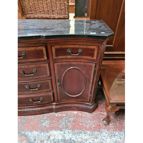 556 - An antique style mahogany serpentine sideboard with solid black marble top, seven drawers and two ou... 