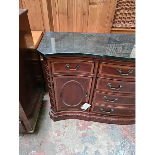 556 - An antique style mahogany serpentine sideboard with solid black marble top, seven drawers and two ou... 