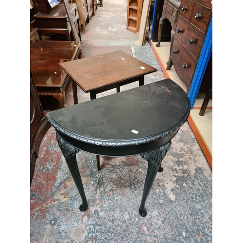 557 - Two items to include an Edwardian oak two tier side table and a modern black painted half moon conso... 