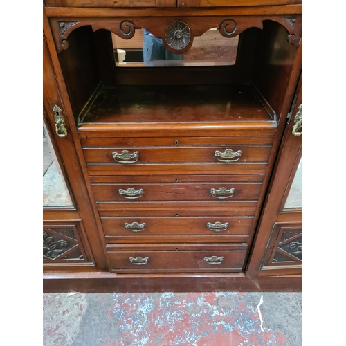 565 - An Edwardian mahogany compactum wardrobe with two bevel edged mirror doors, two upper cupboard doors... 