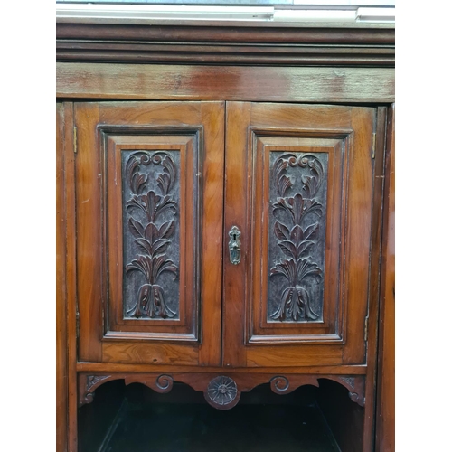 565 - An Edwardian mahogany compactum wardrobe with two bevel edged mirror doors, two upper cupboard doors... 