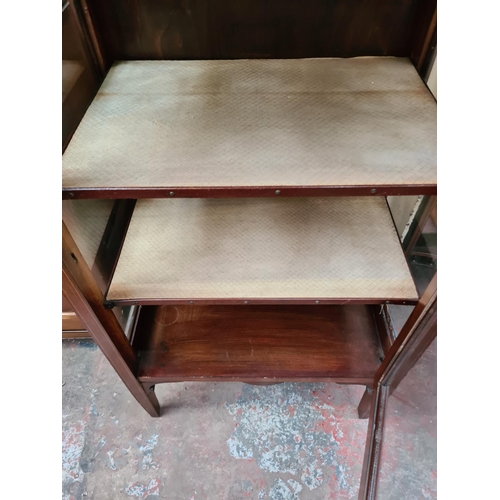 597 - An Edwardian inlaid mahogany display cabinet on tapering supports with one glazed door and key