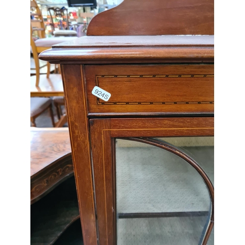 599 - An Edwardian inlaid mahogany display cabinet on tapering supports with one glazed door and key