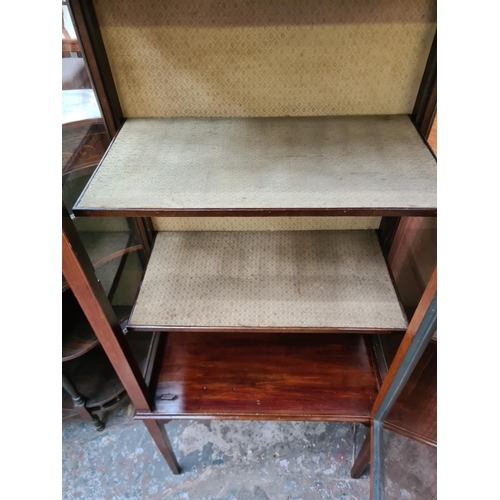 599 - An Edwardian inlaid mahogany display cabinet on tapering supports with one glazed door and key