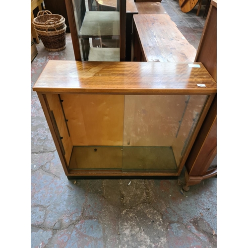 601 - Two items to include a mid 20th century walnut and beech bookcase with two glass sliding doors and t... 