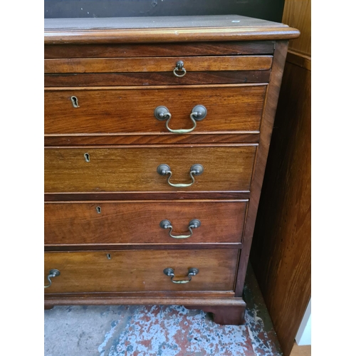 610 - A Georgian style mahogany chest of four drawers on bracket supports with concealed pull out desk