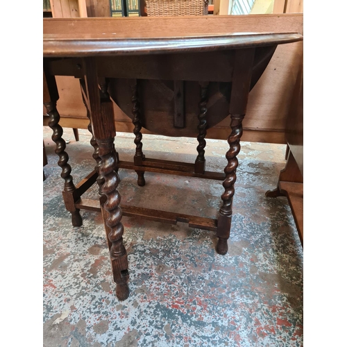 617 - An oak drop leaf dining table on barley twist supports