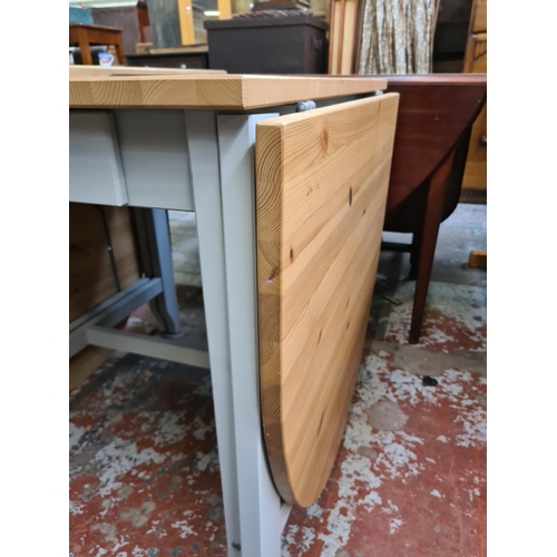 628 - A modern pine and grey painted drop leaf dining table with single drawer