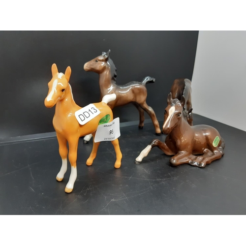 93 - Four Beswick foal figurines to include brown lying foal, palomino foal, head down foal and stretched... 