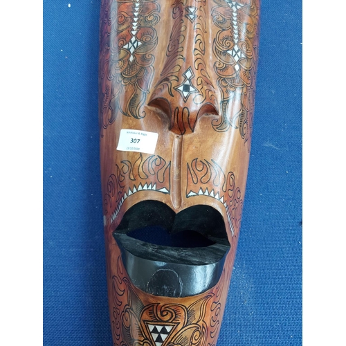 307 - A decorative late 20th century African wall mask with mother of pearl inlay and hand painted decorat... 