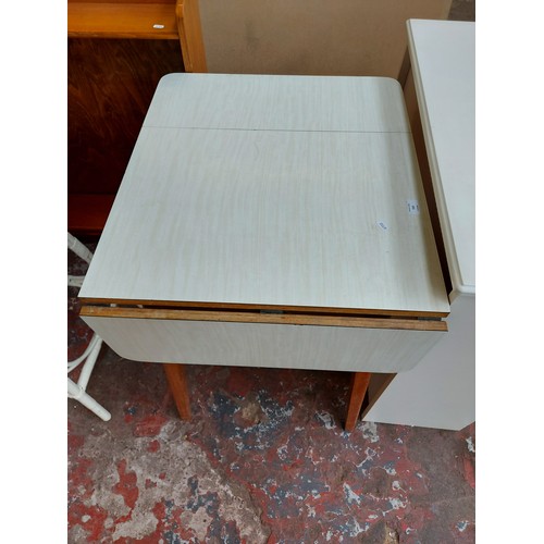 550 - Two items to include a white melamine drop leaf kitchen table and a white laminate freestanding book... 