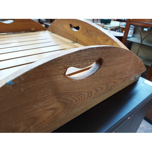 570 - A modern oak butlers foldaway tray