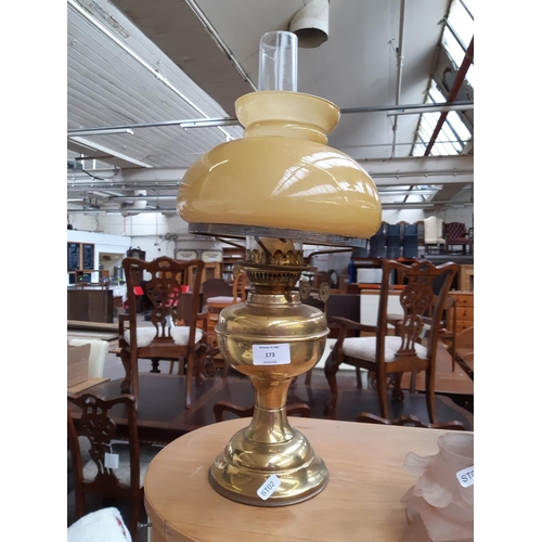 173 - A Victorian Duplex brass oil lamp with amber glass shade and clear glass funnel